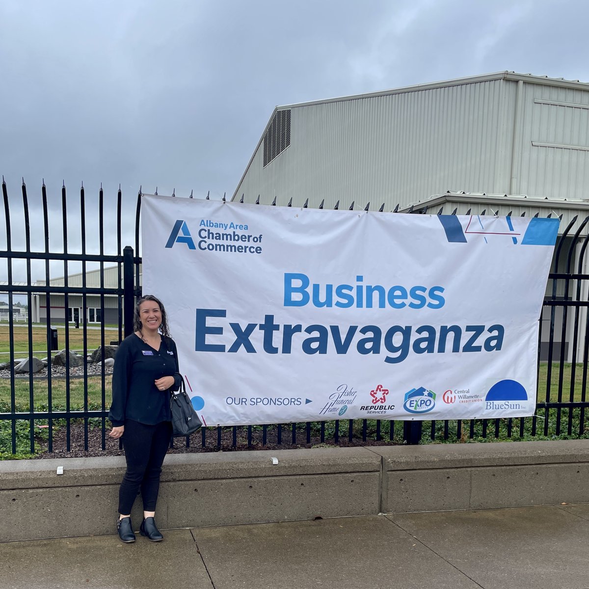 Jessica Wark beside the Albany Area Chamber of Commerce Business Extravaganza banner